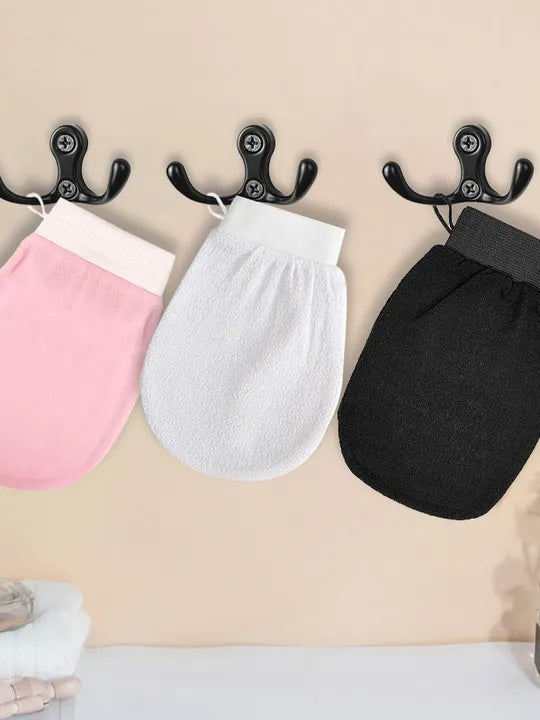 Three exfoliating mitts hanging on hooks